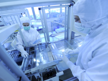 Two production workers packaging medical devices in the clean room
